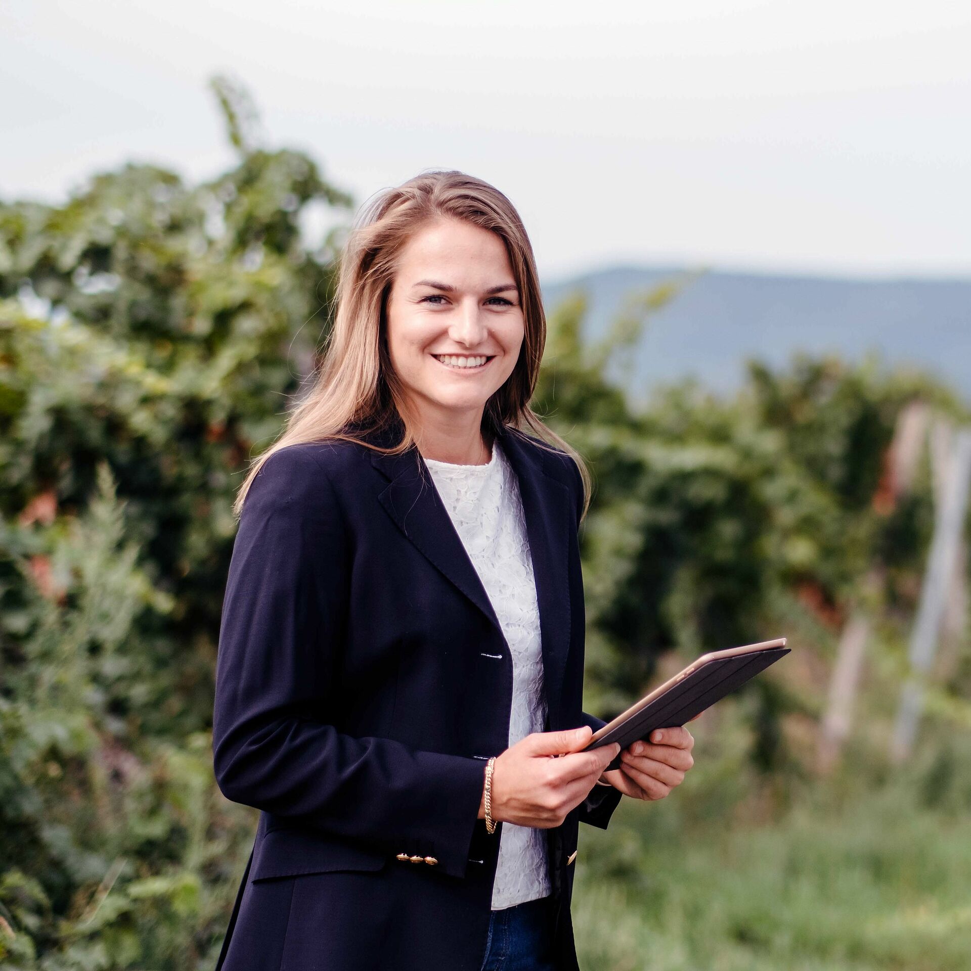 Studentin mit Tablet im Weinberg